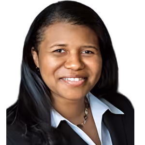 Smiling woman with long black hair wearing a white collared shirt and black jacket against a plain background.