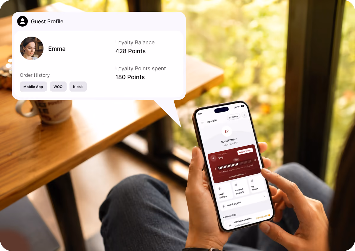 Person holding smartphone displaying a profile screen with loyalty balance and points on a mobile app, with an overlay showing Guest Profile for Emma, loyalty balance of 428 points, 180 points spent, and order history from Mobile App, WOO, and Kiosk.
