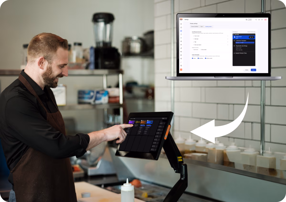 A man wearing a black shirt and brown apron operates a touchscreen point-of-sale system in a kitchen, with a white arrow pointing to a laptop screen showing order settings and a live order preview.