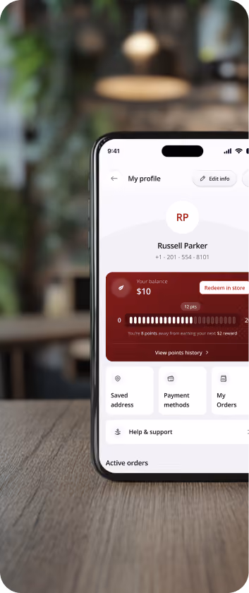 Smartphone screen displaying a user profile for Russell Parker with a visible phone number and a rewards balance of $10, showing 12 points and a progress bar towards a $2 reward, plus options for redeeming points, viewing saved address, payment methods, orders, and help and support.
