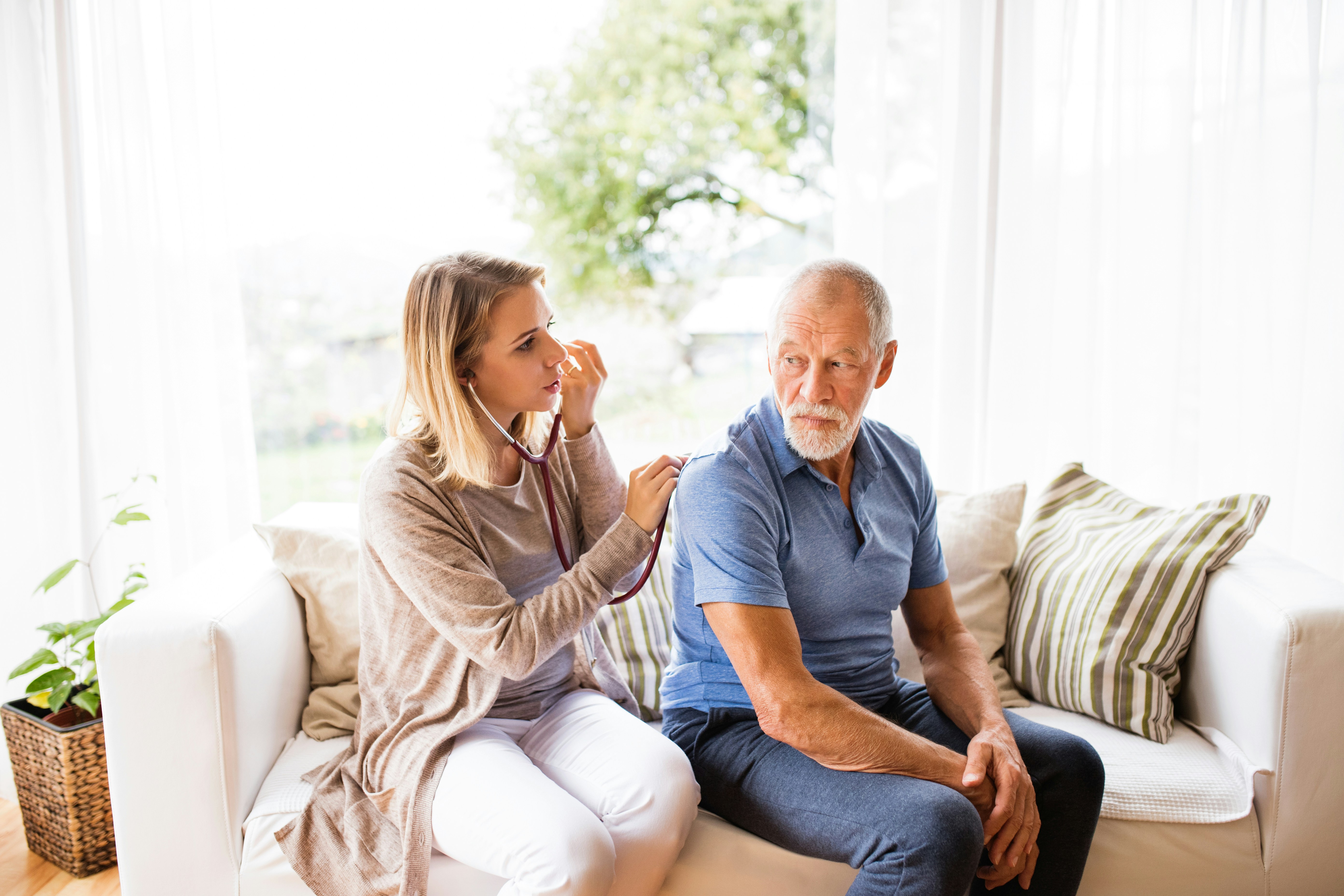 Medical professional taking elderly mans vitals