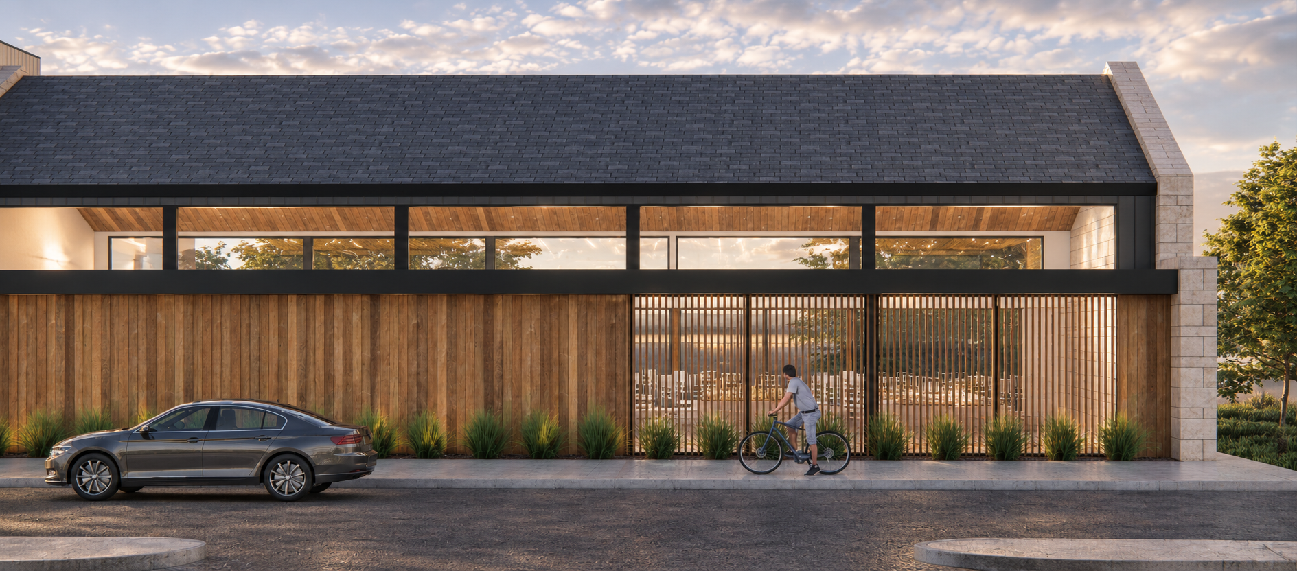 Modern event center with glass triangular roof, wooden and stone exterior, surrounded by trees and people.