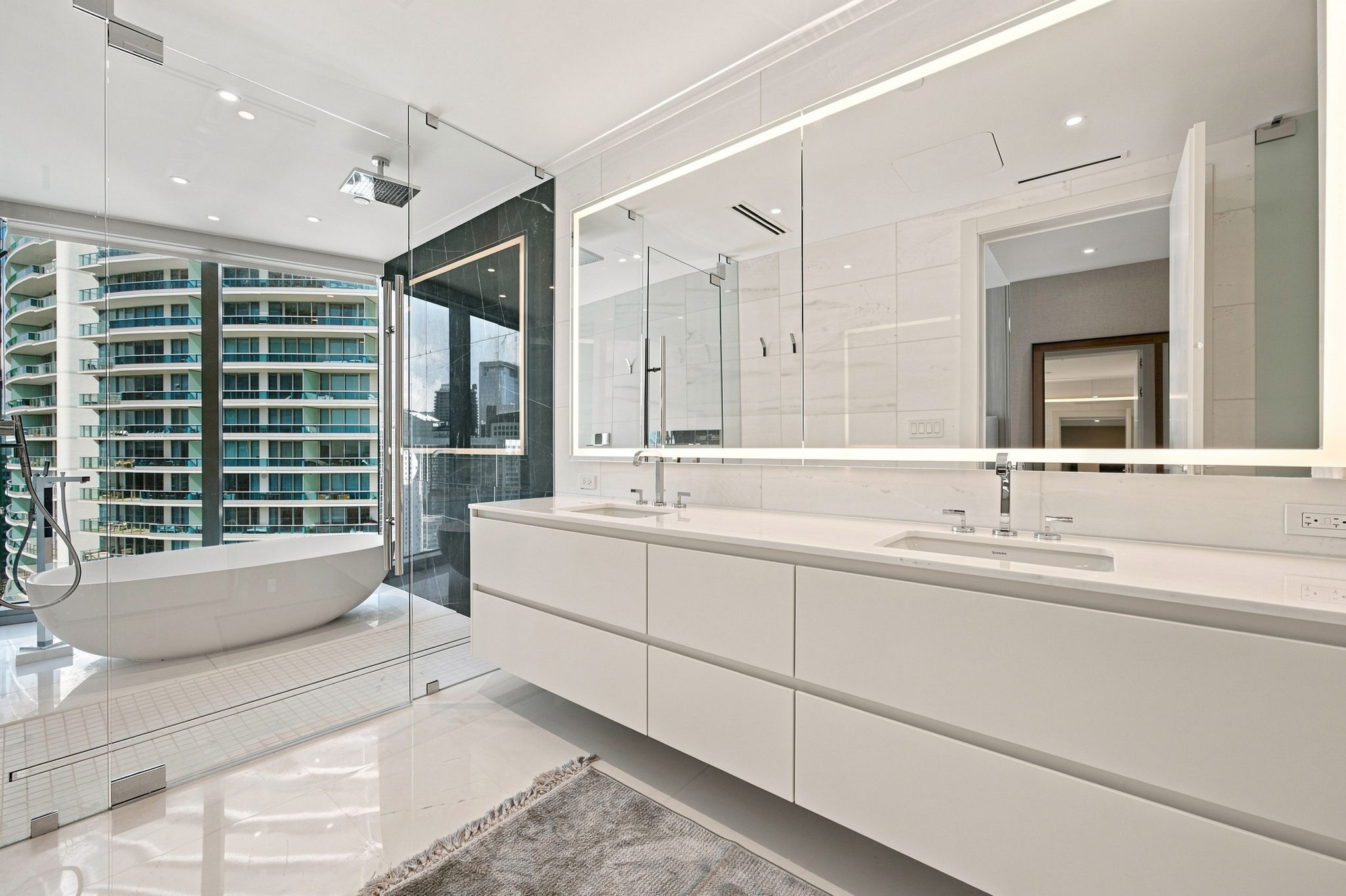 Primary bathroom with soaking tub and glass shower — Residence 3807
