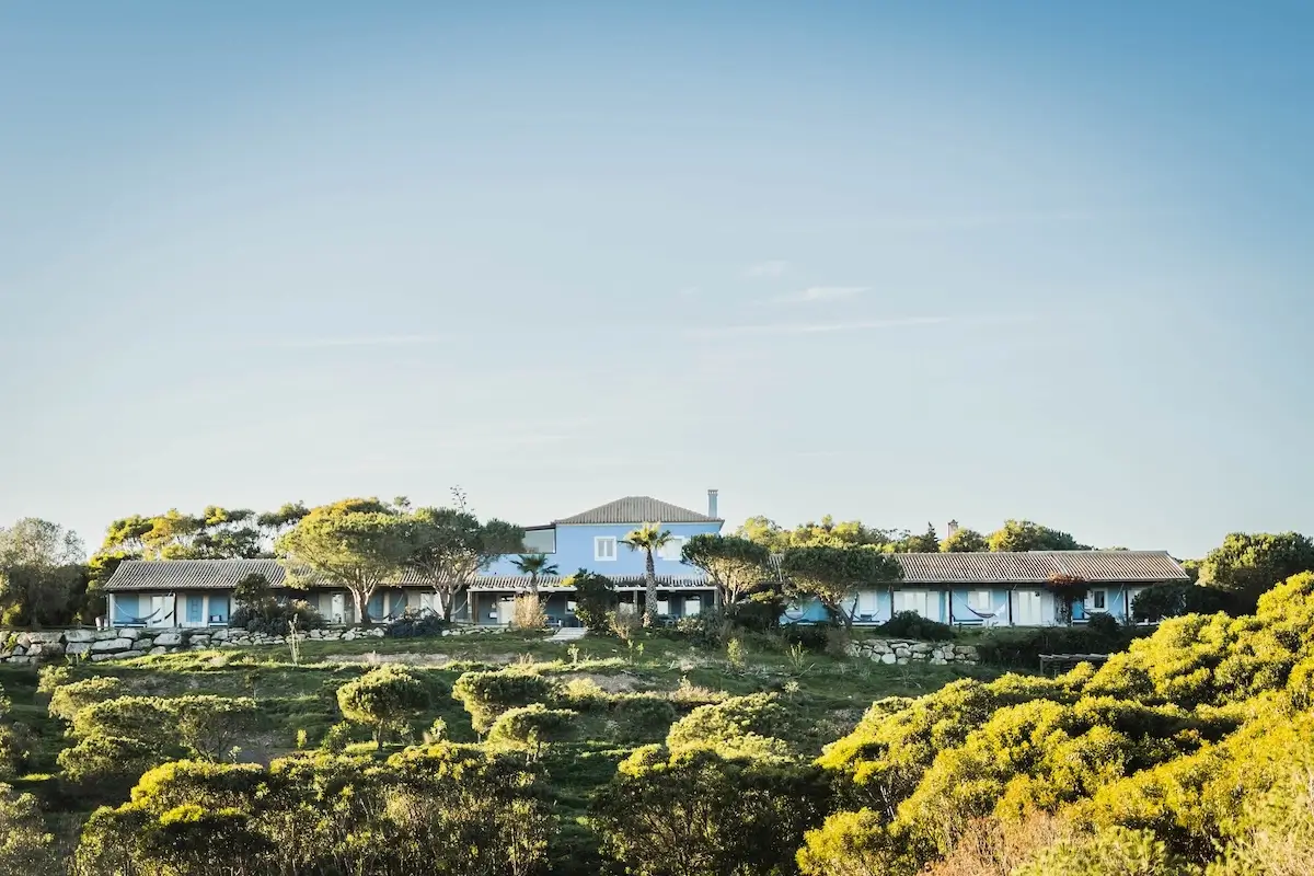 Retreat centre in Portugal surrounded by lush nature with sunlight streaming down, creating a peaceful, welcoming atmosphere.