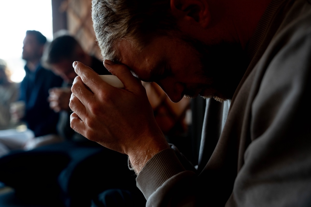 A man presses a cup to his forehead in reflection at The Return of Men men's retreat, Comporta, November 2024.