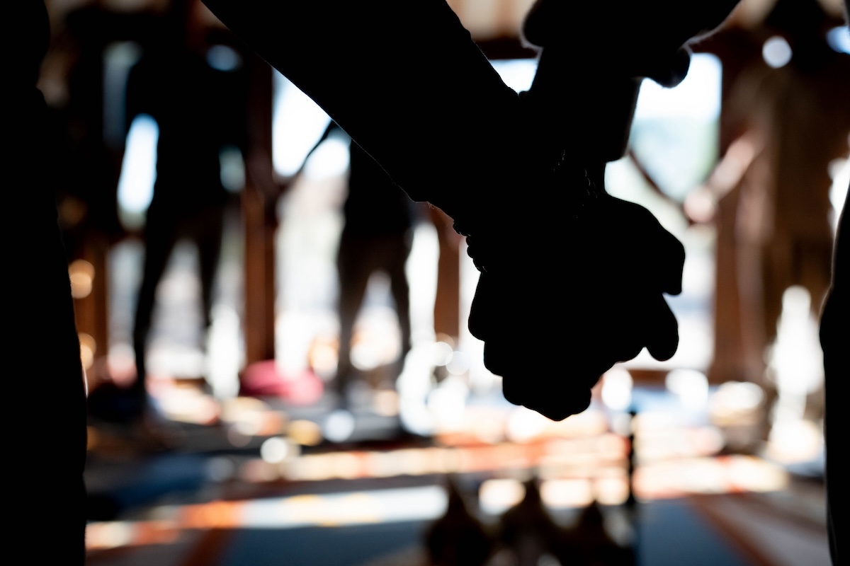 Silhouette of two men's clasped hands inside the yurt at The Return of Men retreat, Portugal, November 2024.