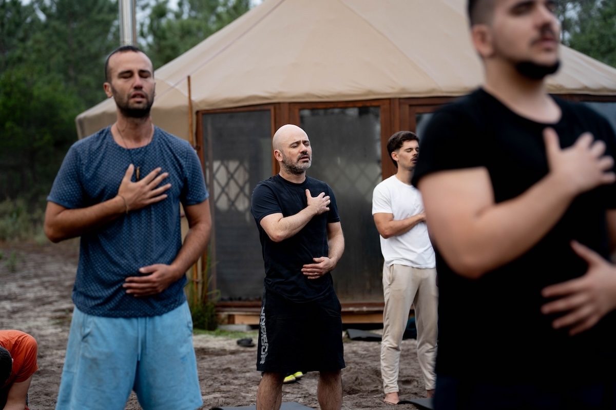 Men stand in breathwork practice outside the yurt at The Return of Men retreat, Wim's Land, Comporta, 2024.