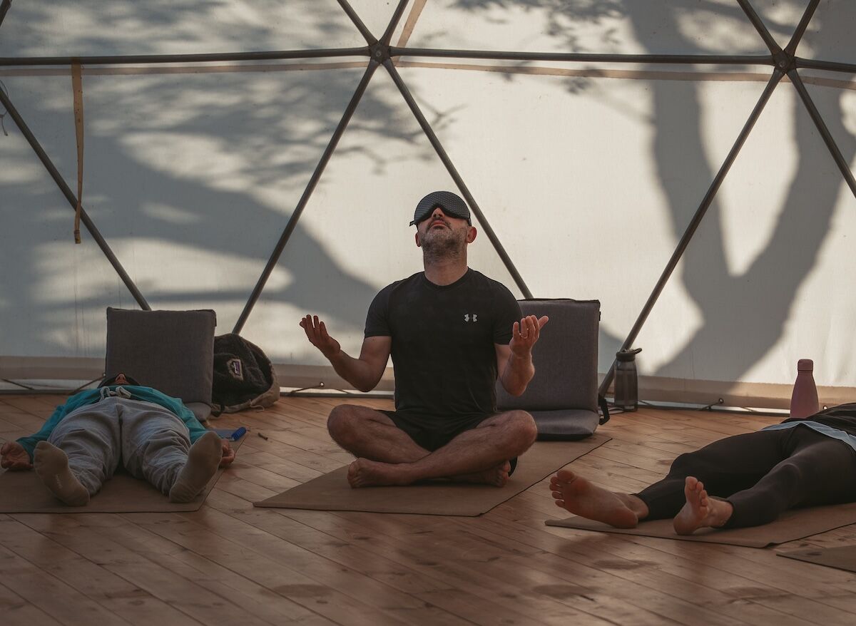 Man raising his arms peacefully toward the sky, symbolising clarity, acceptance, and freedom.