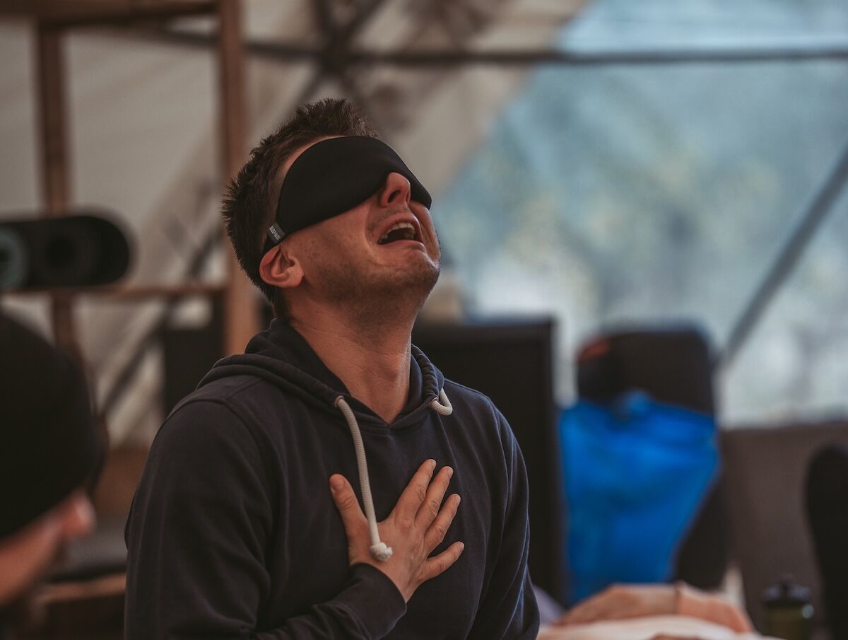A blindfolded man cries out with a hand on his heart at The Return of Men retreat, BioVilla, October 2025.