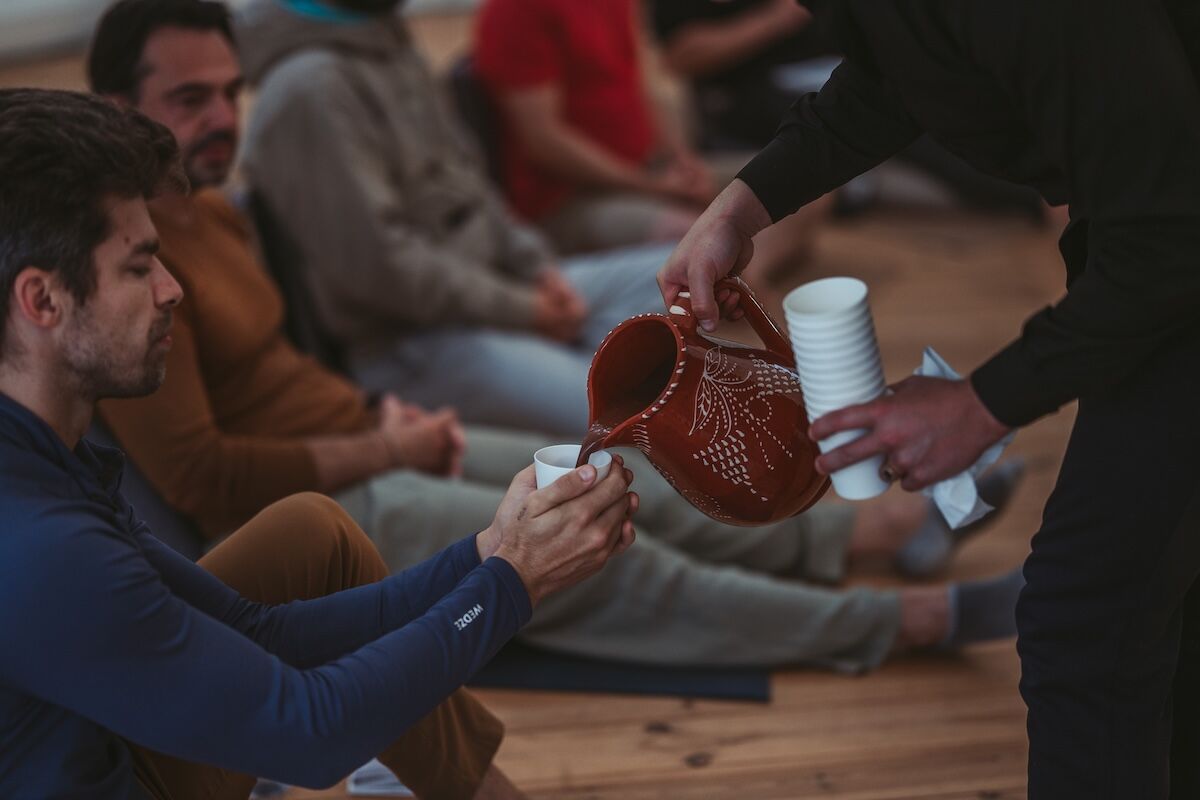 Ceremonial cacao is poured into the men's cups in the dome at The Return of Men retreat, October 2025.