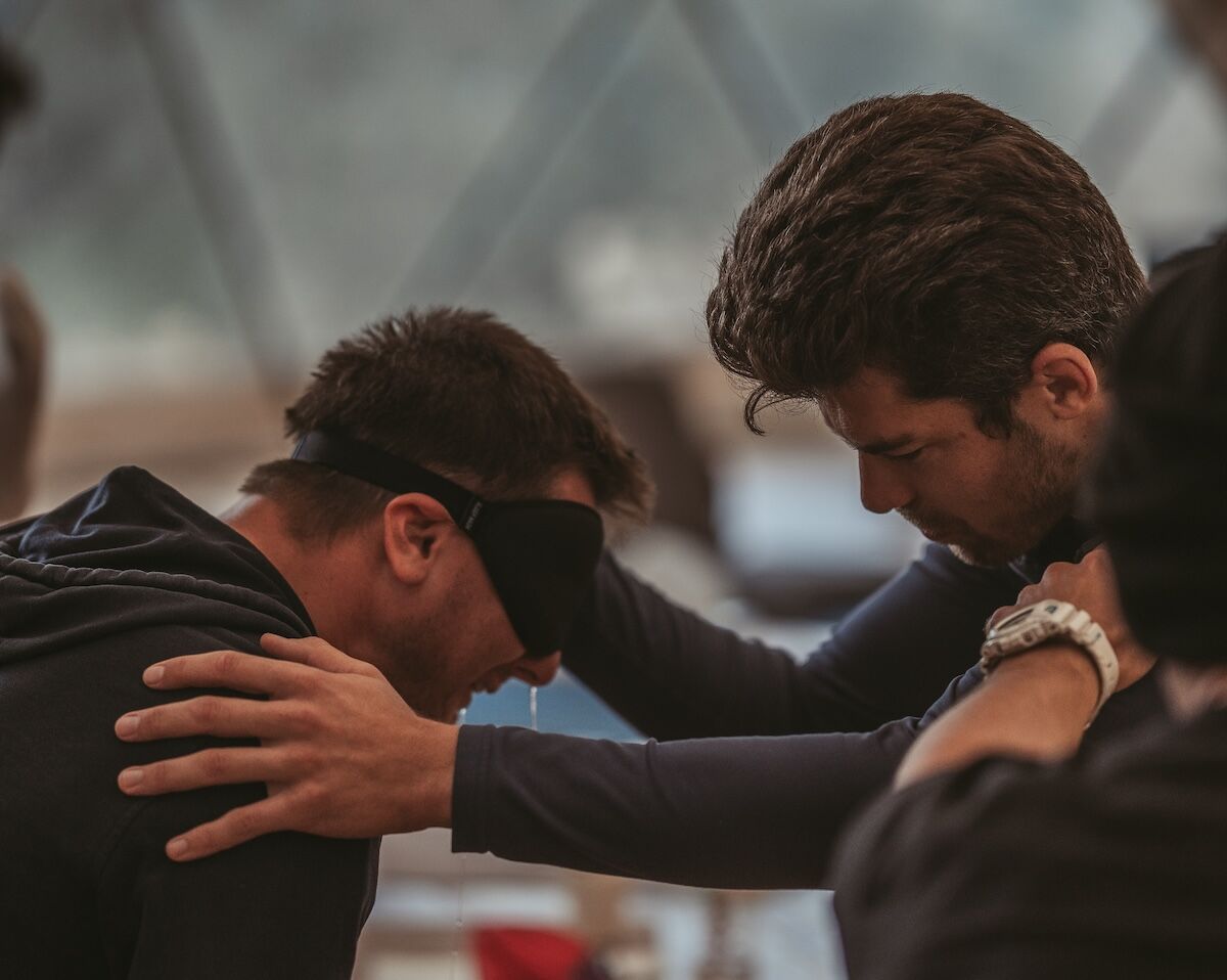 Man supporting another through deep emotion, symbolising emotional work, integrity, and the power of holding space for others.