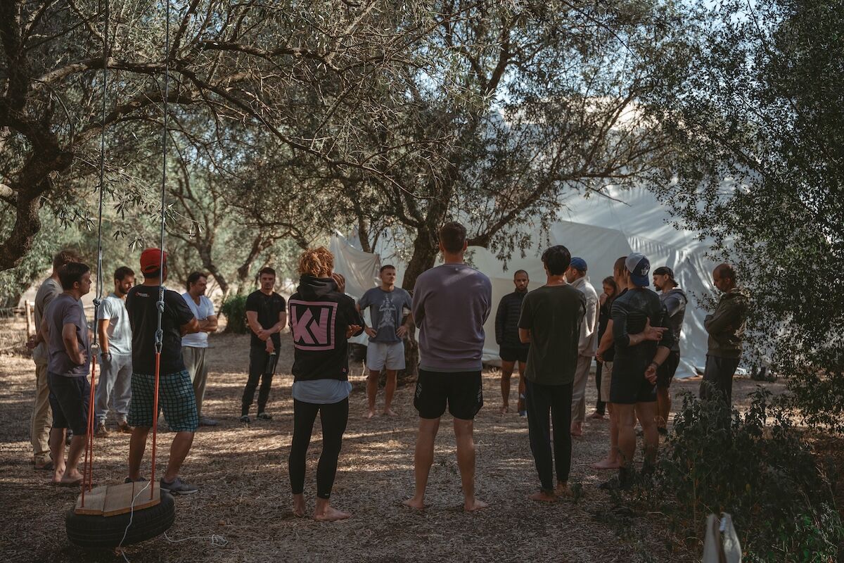 The men stand in a circle beneath the olive trees beside the dome at The Return of Men retreat, BioVilla.