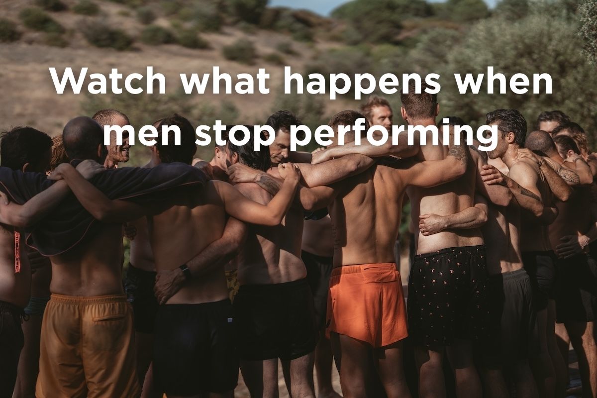 Men standing in a circle embracing and smiling in nature after an ice bath ritual, symbolising brotherhood, presence, and renewed vitality.