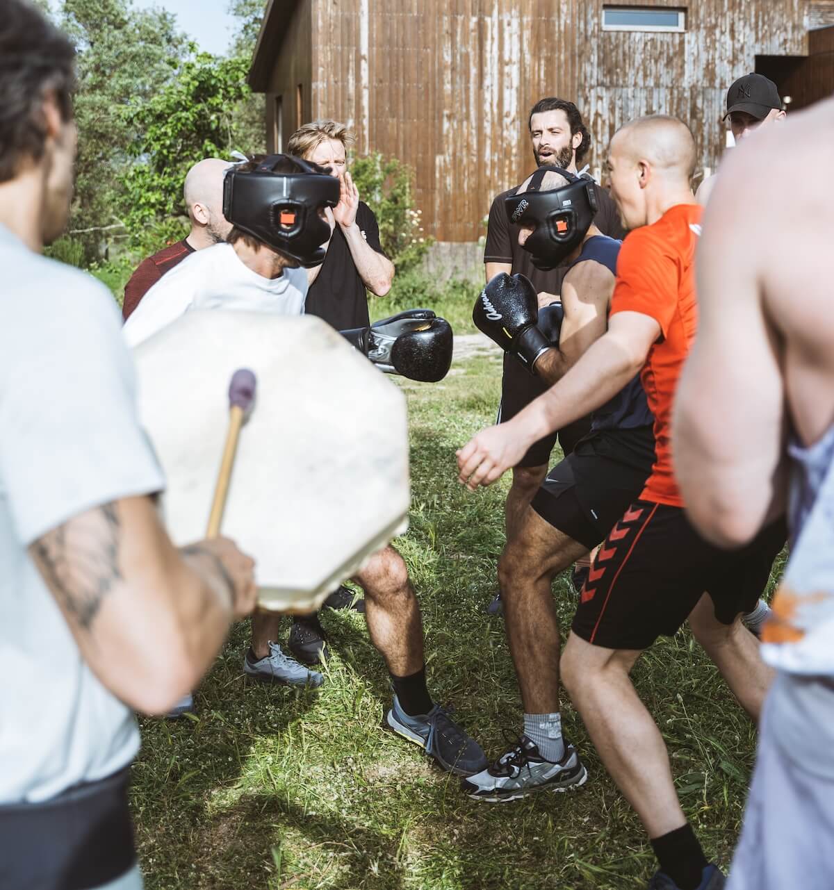 Two men in headguards spar to the beat of a frame drum at The Return of Men retreat, BioVilla, Portugal, 2026.