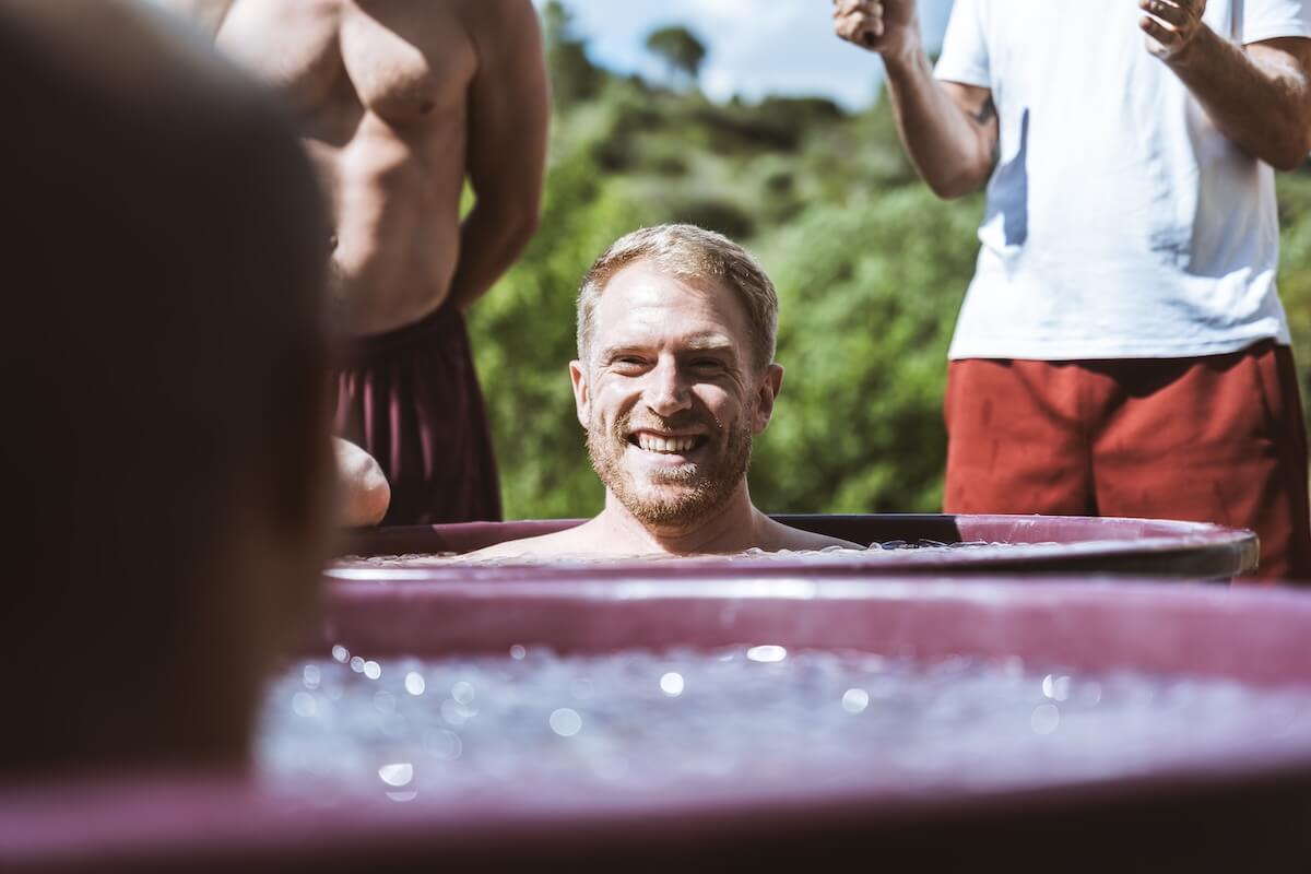 A man beams from the ice bath as the men cheer him on at The Return of Men retreat, Arrábida, 2026.
