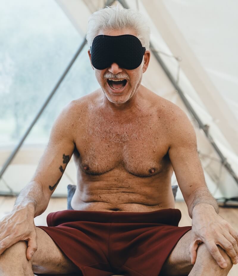 A silver-haired man, blindfolded, opens into release during inner work at The Return of Men retreat, May 2026.