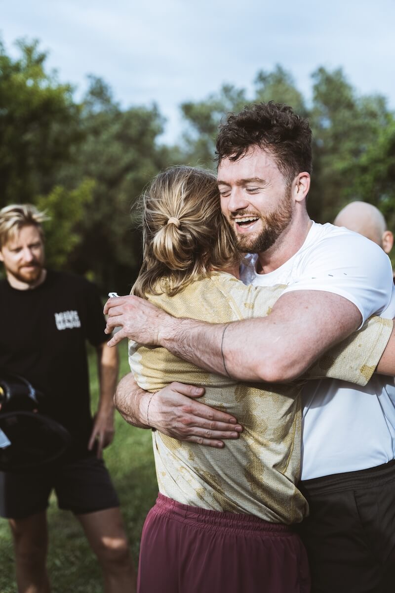 Two men hold a strong embrace after the challenge at The Return of Men retreat, BioVilla, Portugal, 2026.