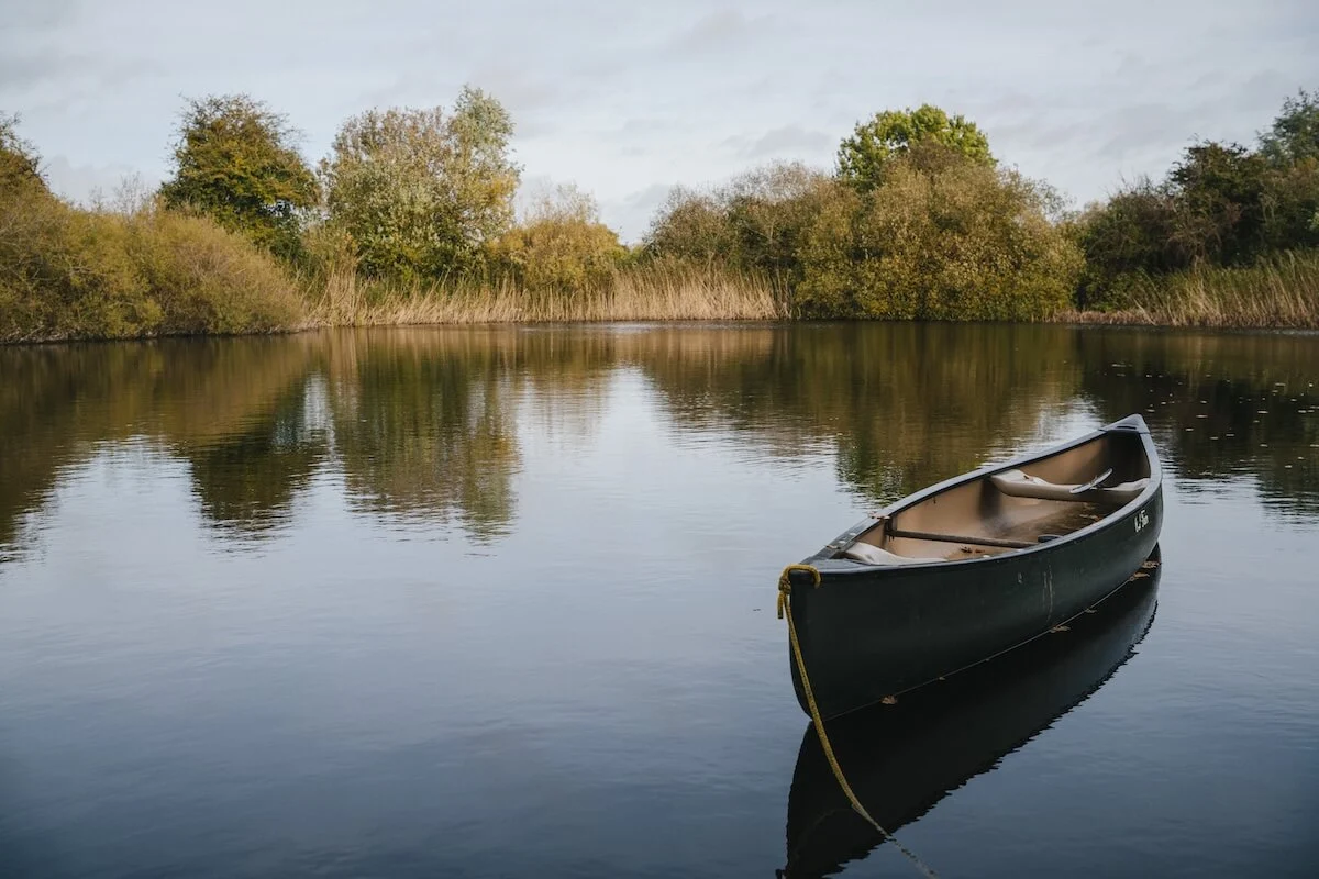 A canoe on the still water of Elmore's swimming pond