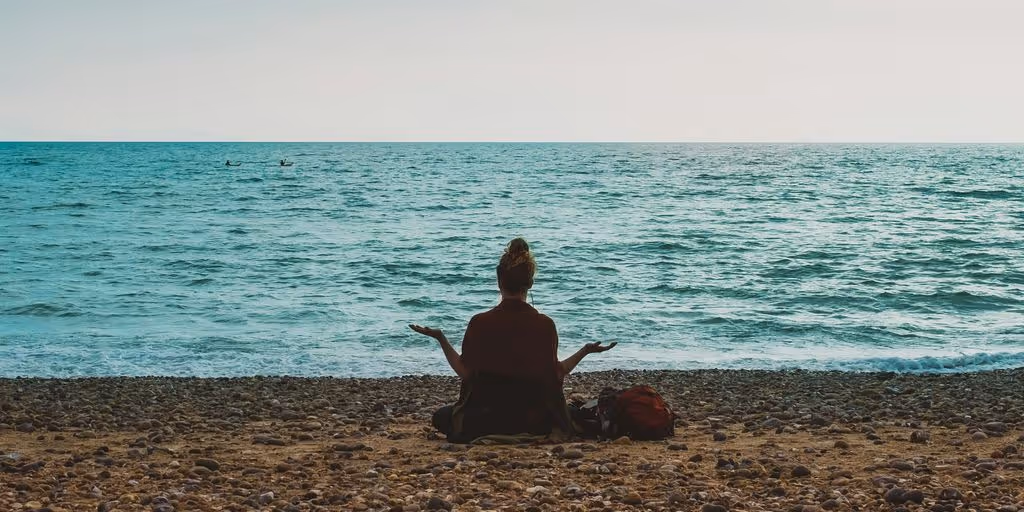 person doing yoga on seashore during daytime