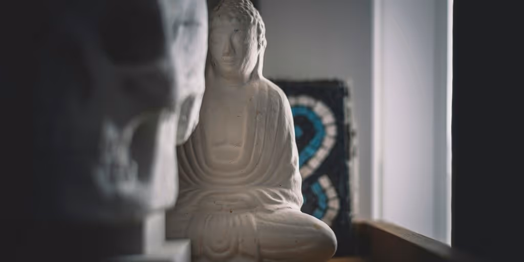 white ceramic buddha figurine on brown wooden table