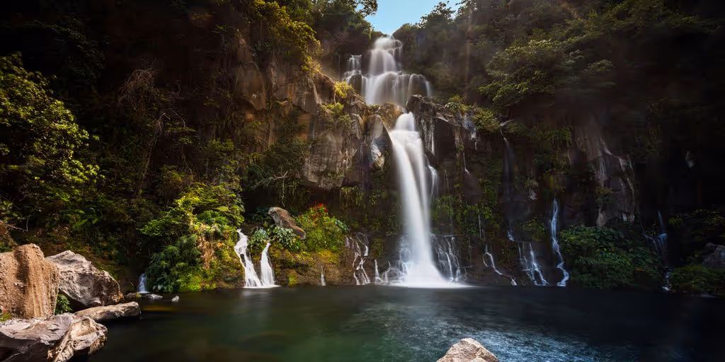 waterfalls in the middle of the forest during daytime