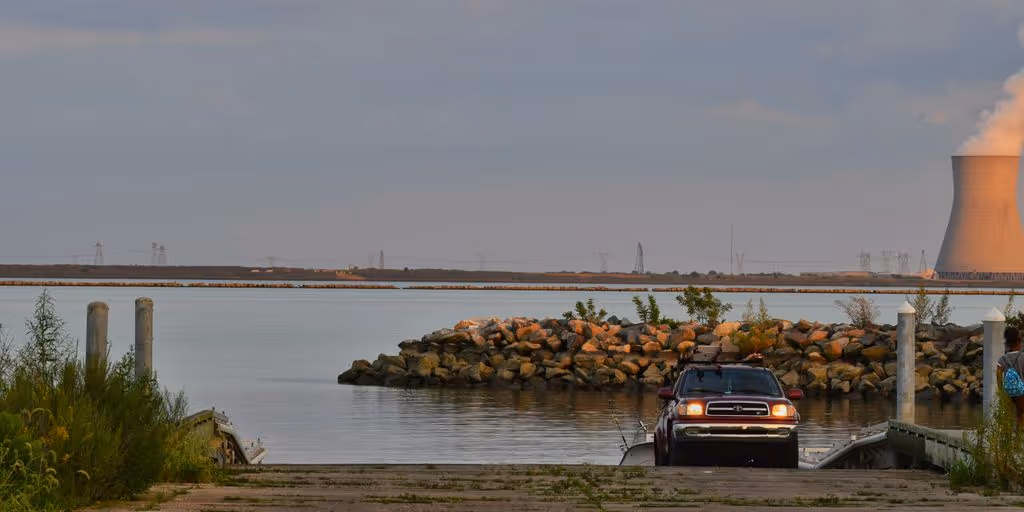 a car parked on a road by a body of water