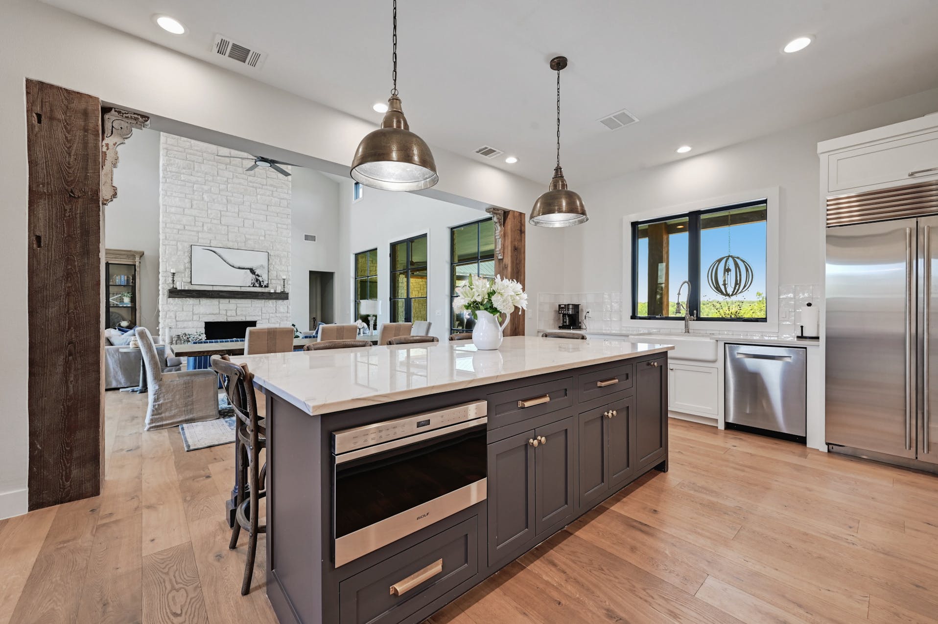 Kitchen with a dark island, white cabinets and stainless steel refrigerator
