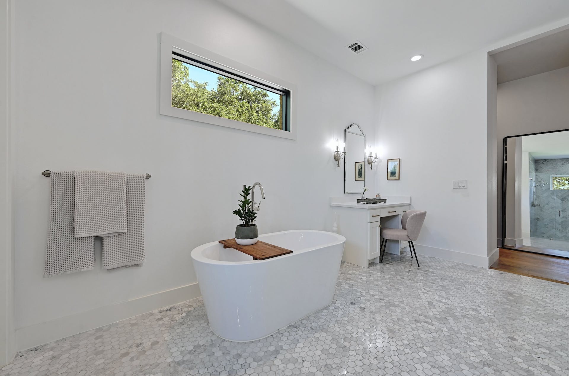 Freestanding soaking tub beneath a long clerestory window