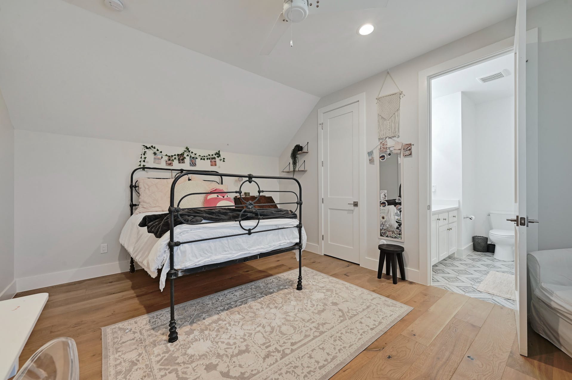 Bedroom with a black iron bed and adjoining bathroom