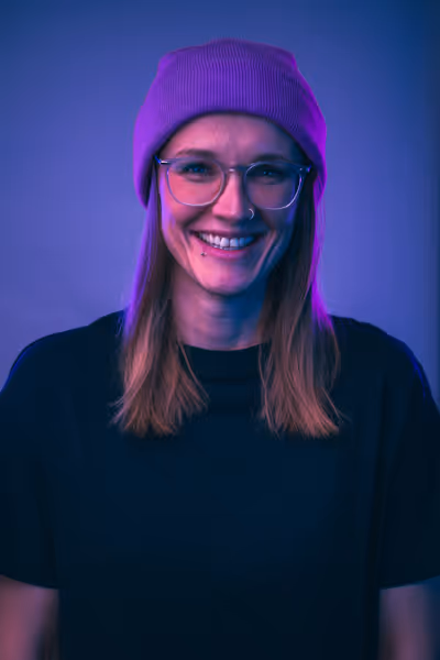 Brenda - Mitarbeiterin von WE ARE HYPE steht vor einem Lila Hintergrund und lächelt in die Kamera