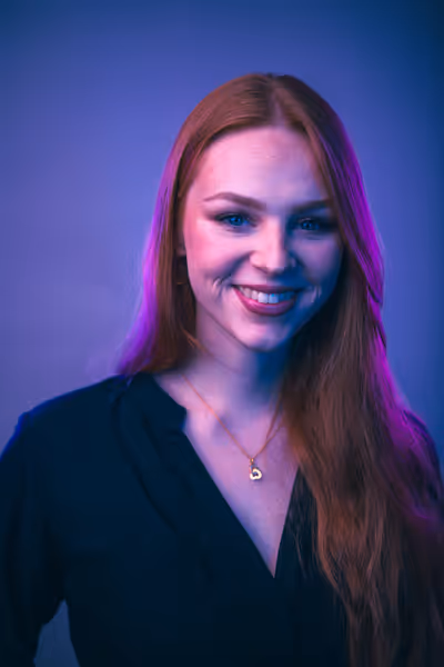 Leonie - Mitarbeiterin von WE ARE HYPE steht vor einem Lila Hintergrund und lächelt in die Kamera.