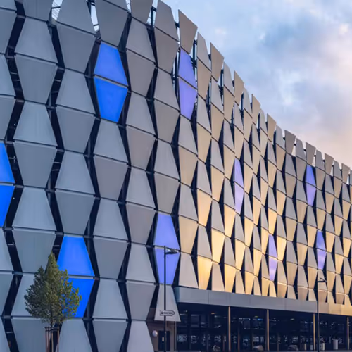Schöne Fassade mit LED Elementen bestückt. Leuchtet in Blau im Sonnenuntergangslicht.