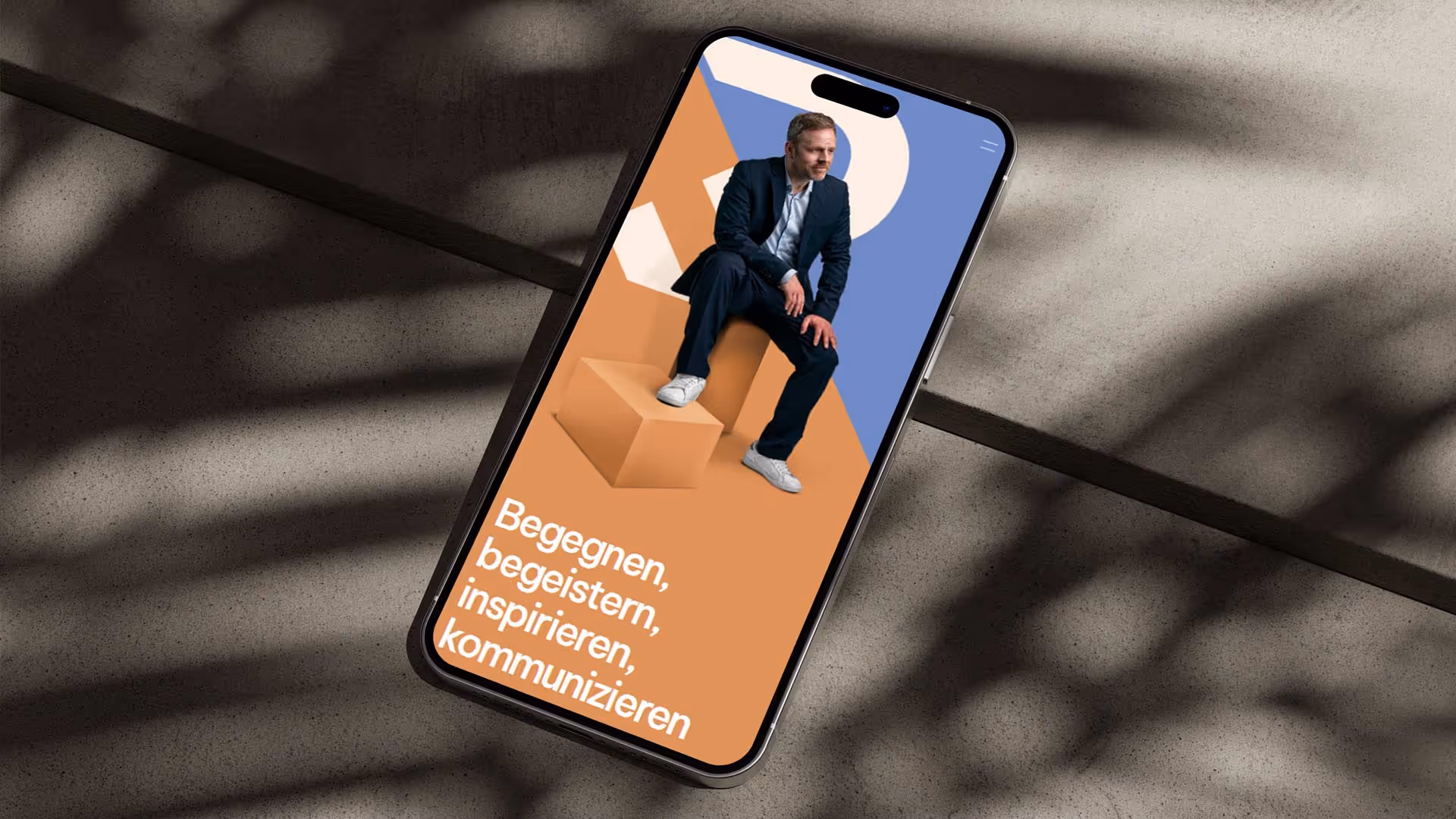 Iphone liegt auf Betonboden und zeigt die Website von Robert Bittig in der mobilen Ansicht.