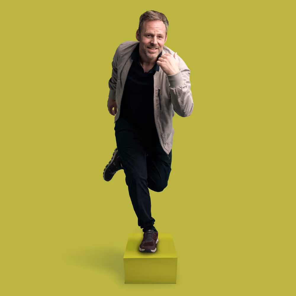 Robert Bittig lässig surfend auf einem Karton vor einem hellgrünen Hintergrund