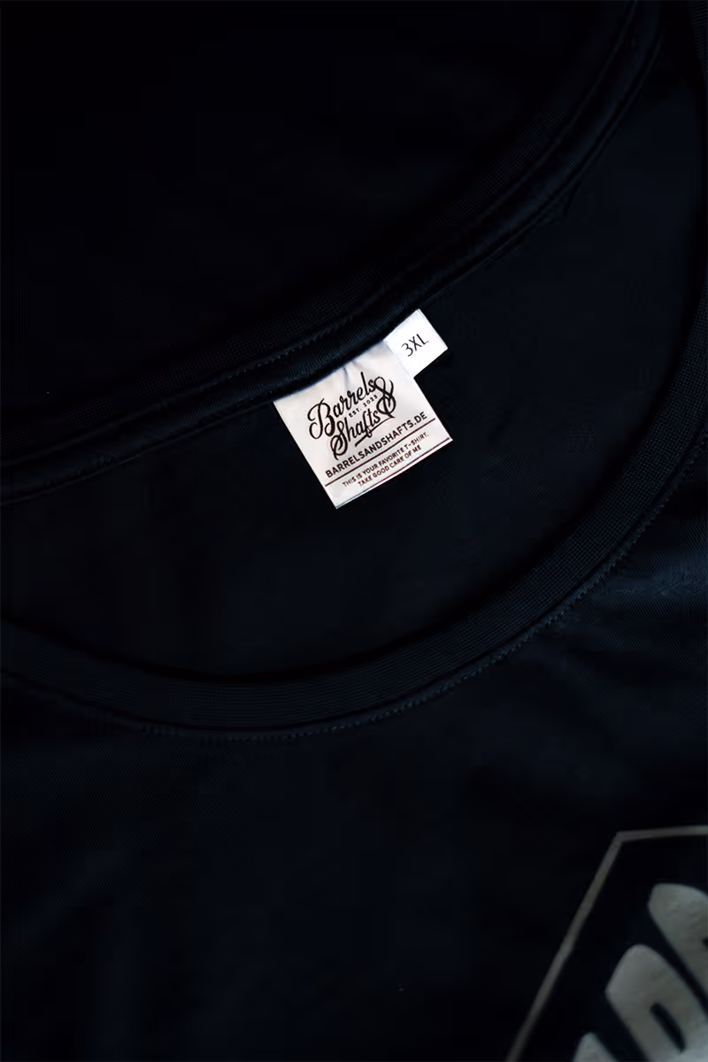 Label eines T-Shirts einer Klamottenmarke. Weiß auf Schwarz.