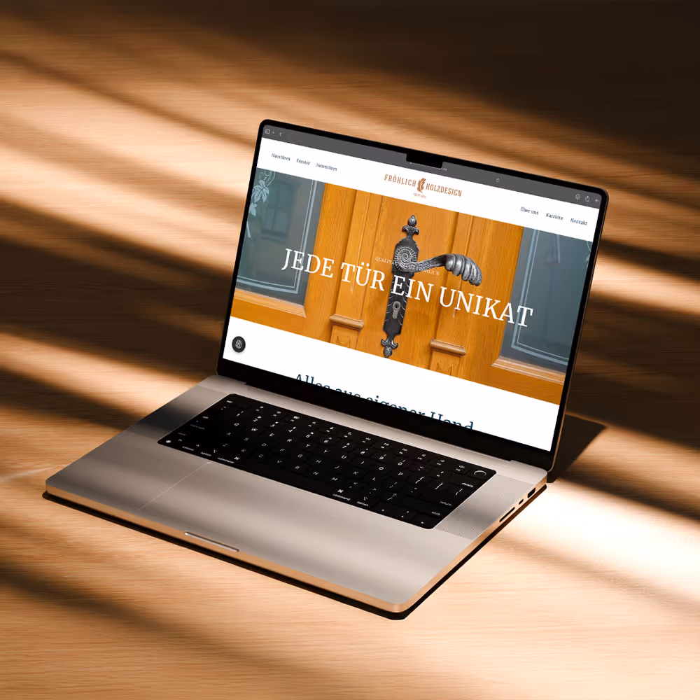 Macbook steht auf Holzboden aufgeklappt und zeigt ein Browserfenster mit einer Website