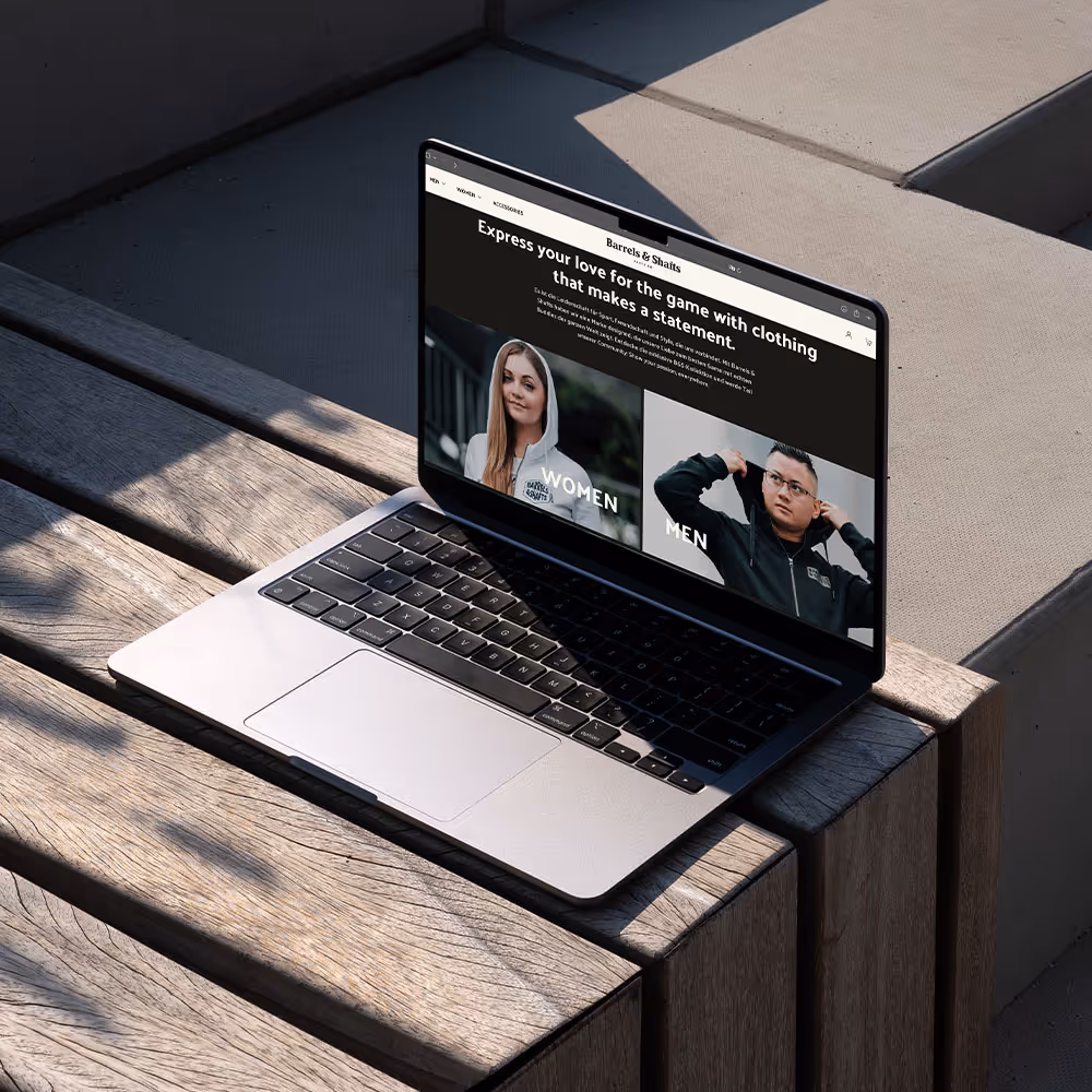 Macbook aufgeklappt in der Sonne stehend auf einer Holzbank
