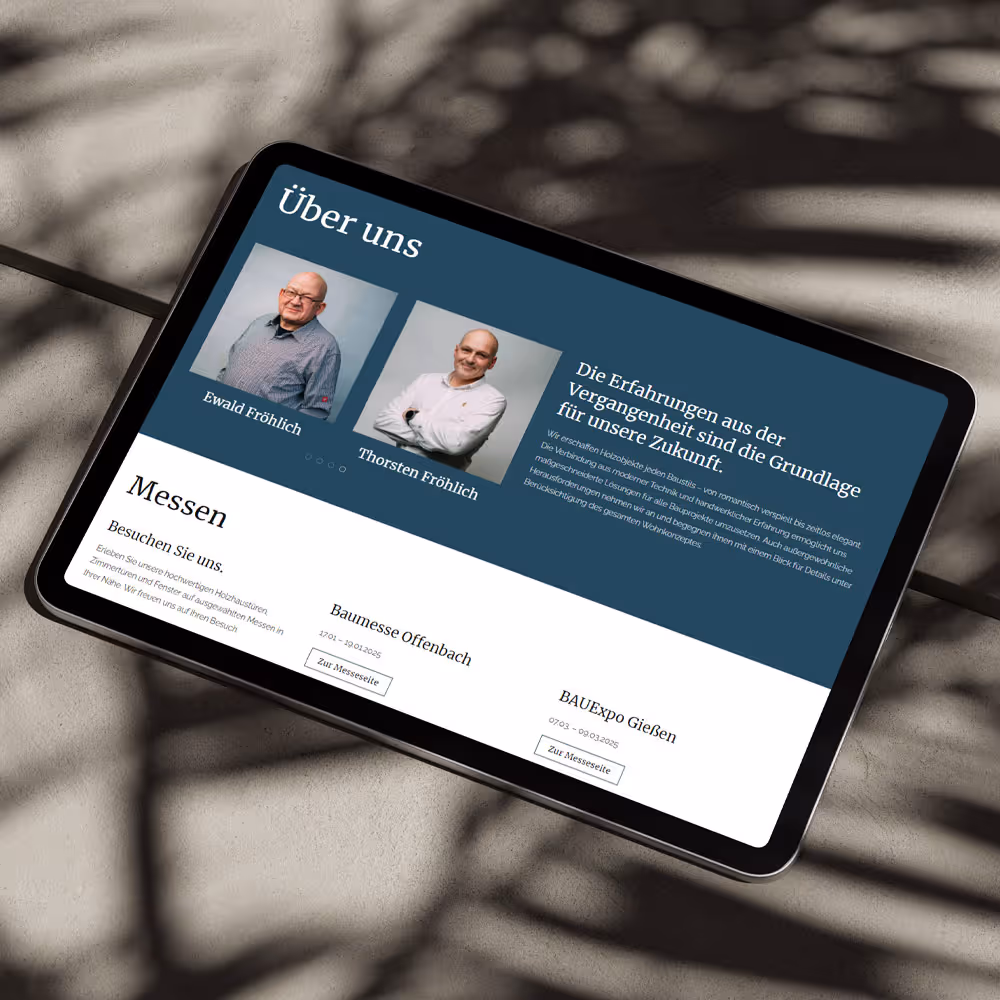 Tablet liegt auf Betonboden und zeig mobile design einer Website in Querformat.