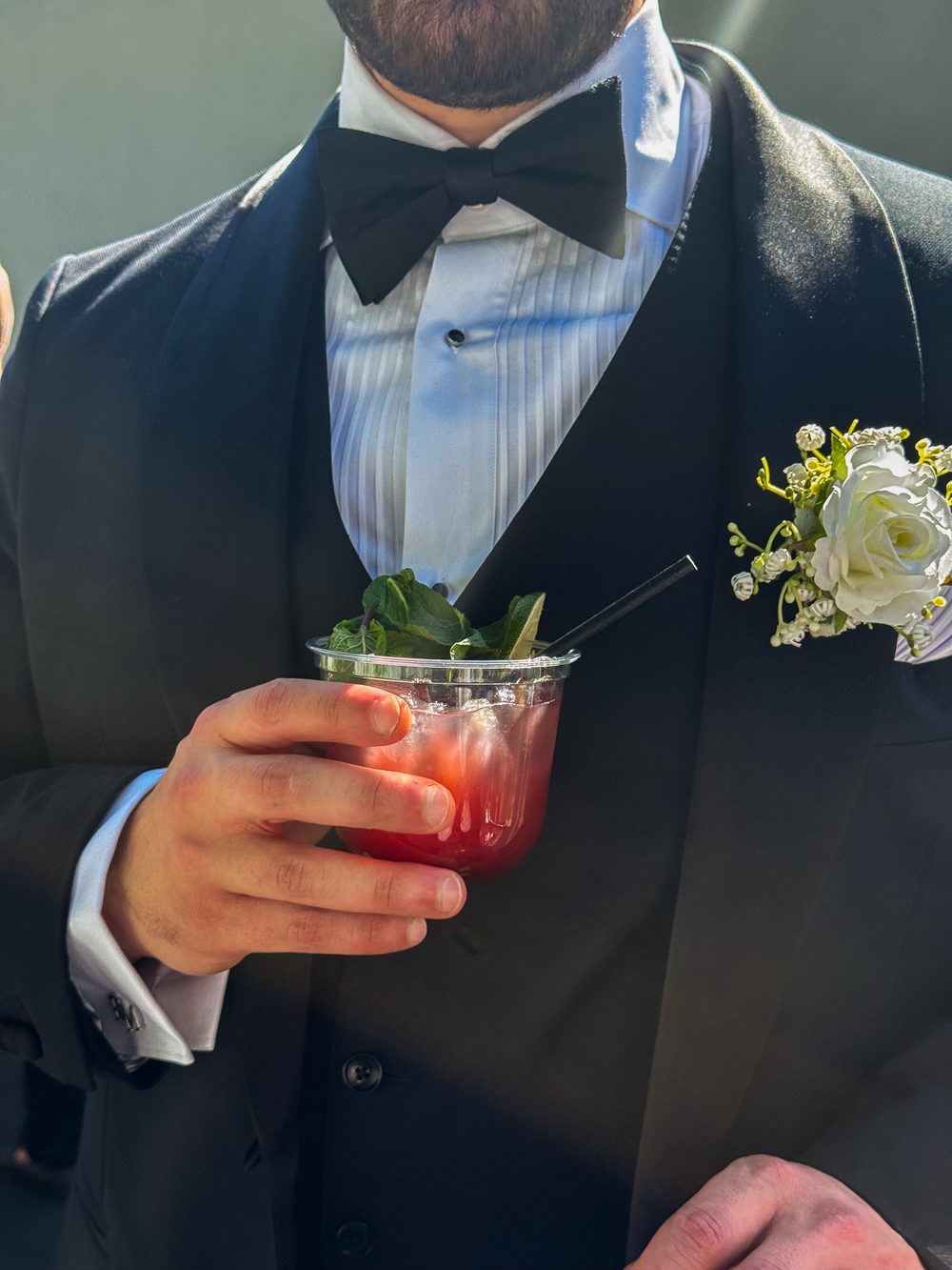Groom holding a signature mocktail