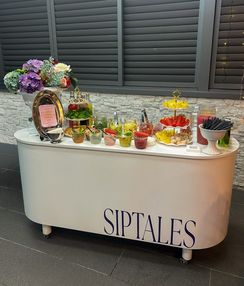 SipTales bar styled with florals for a celebration