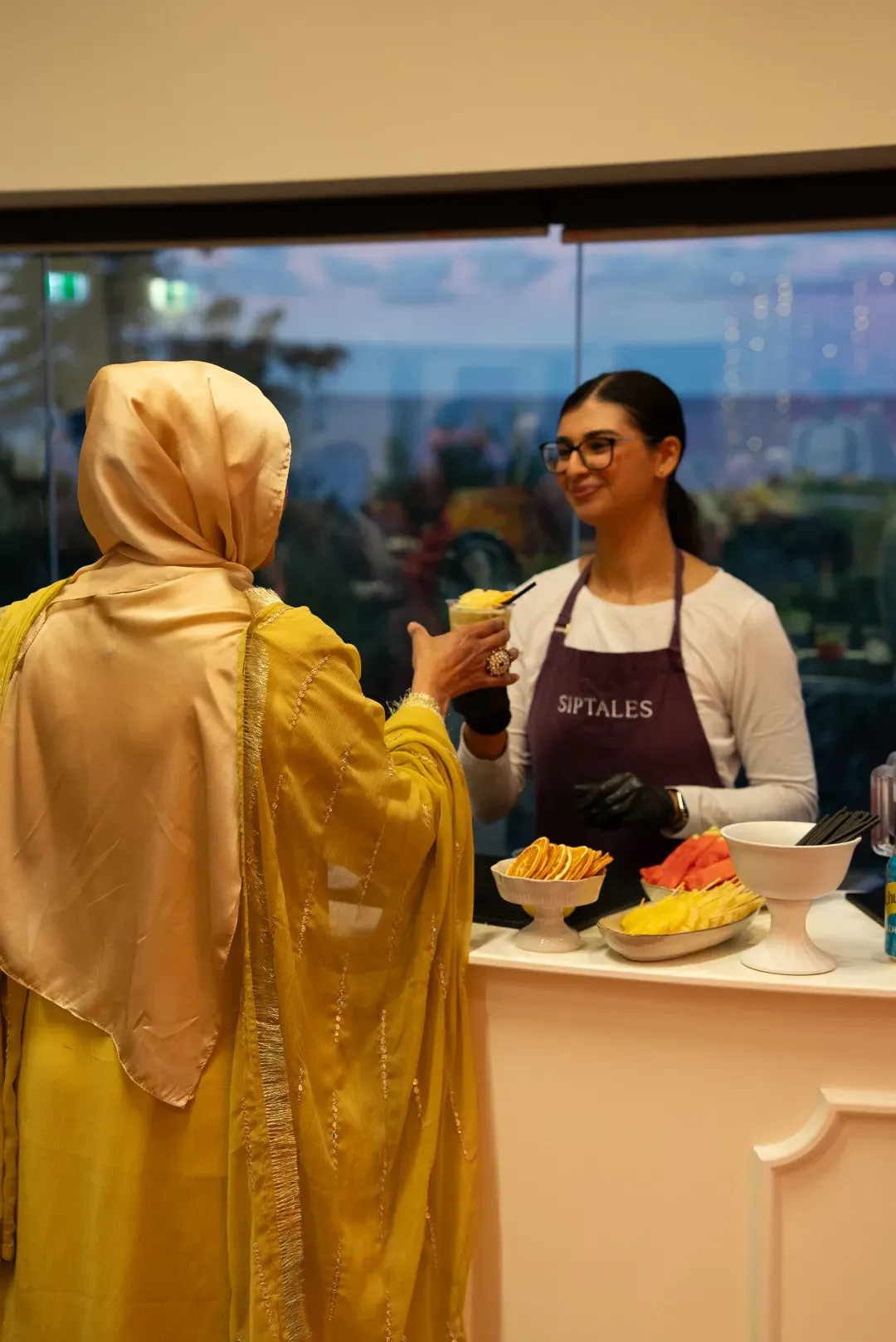 Mixologist handing a mocktail to a guest