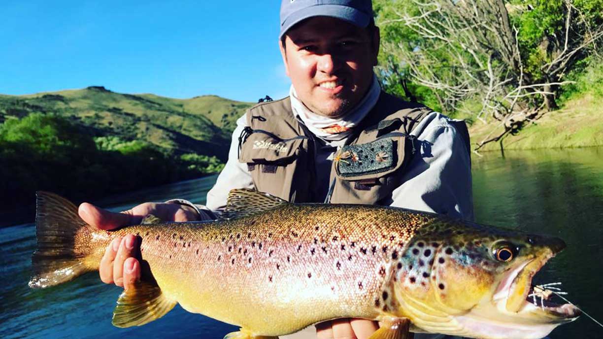 Guest with a brown trout catch at Bravo Sur Lodge