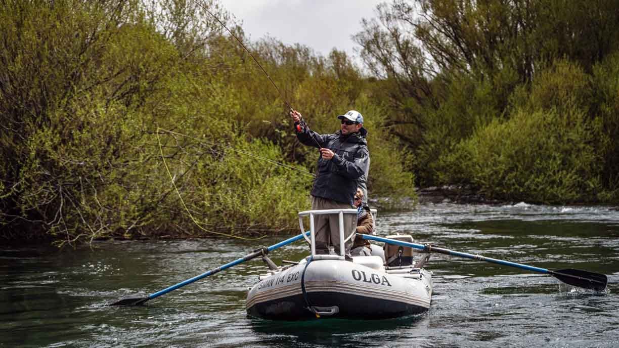Fly angler casting from a drift boat on a Patagonian river