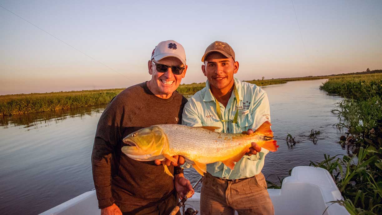 Guide and angler with a golden dorado taken on bait on the Paraná