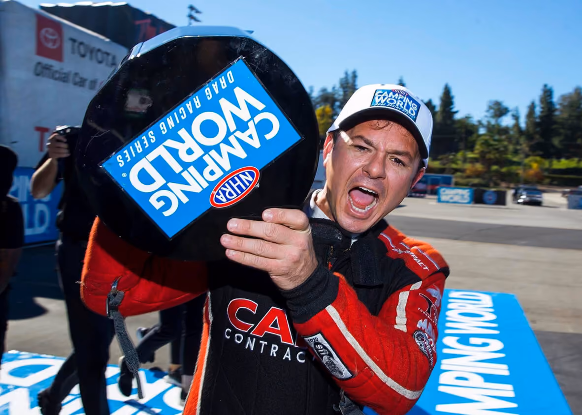 Steve Torrence holds up his NHRA World Championship trophy.