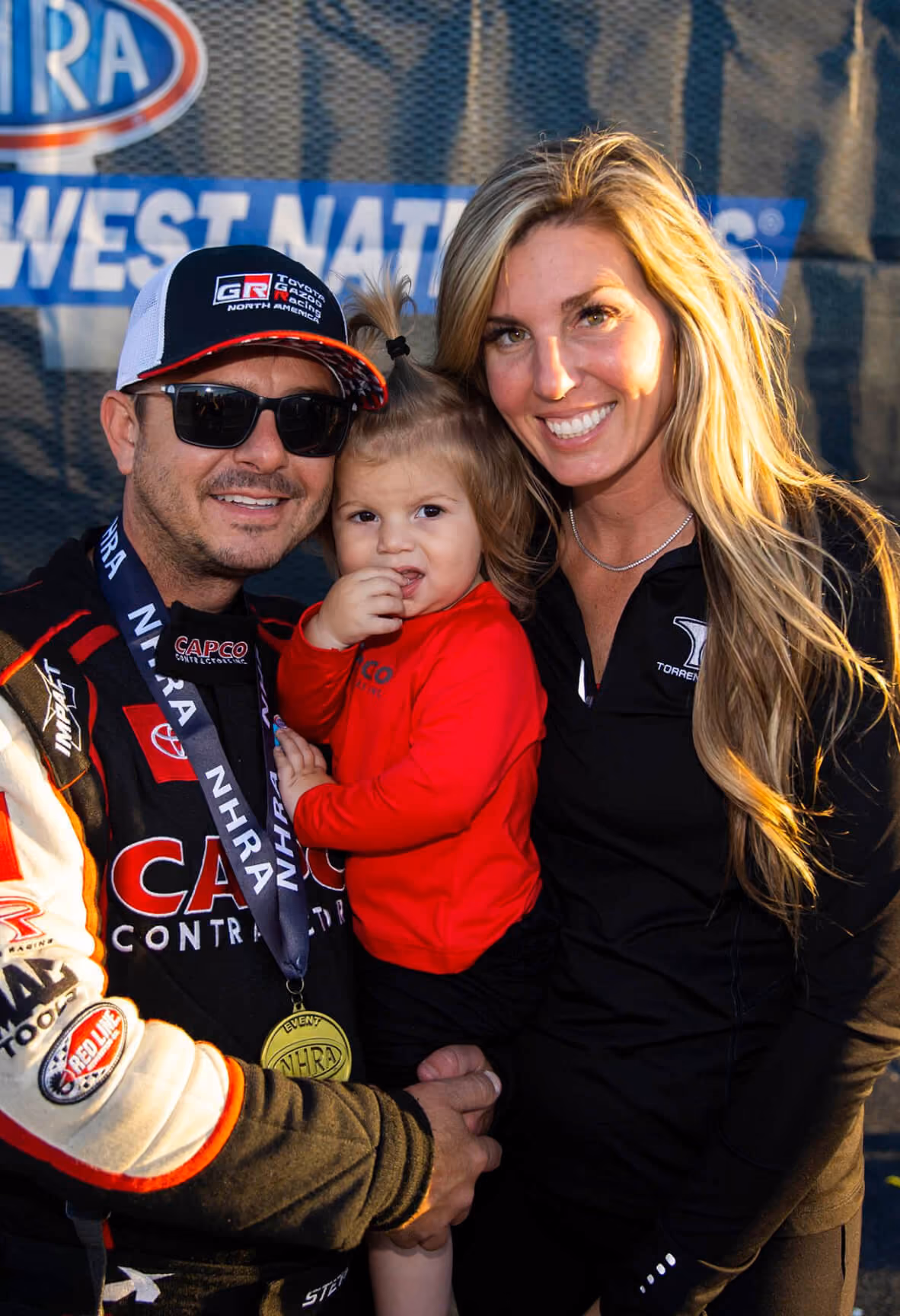 Steve and Natalie Torrence hold their daughter after winning an NHRA National Event in St. Louis, Missouri.