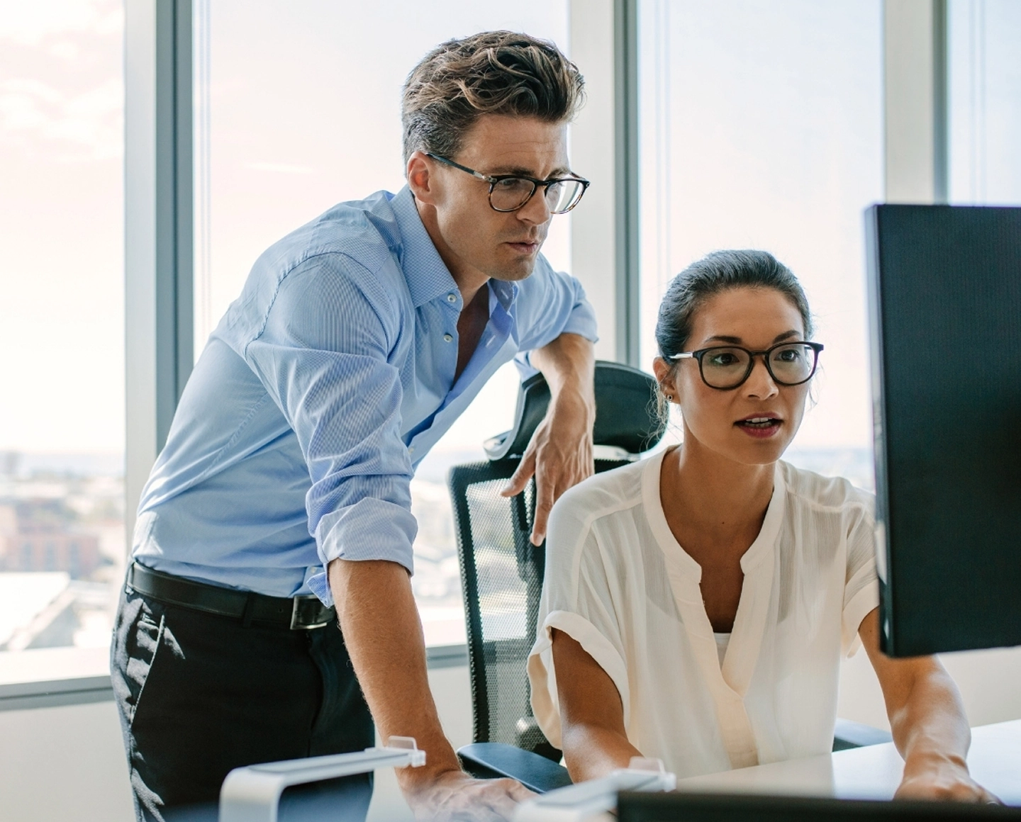 Marketing professionals reviewing CaliberMind analytics data on computer screen.