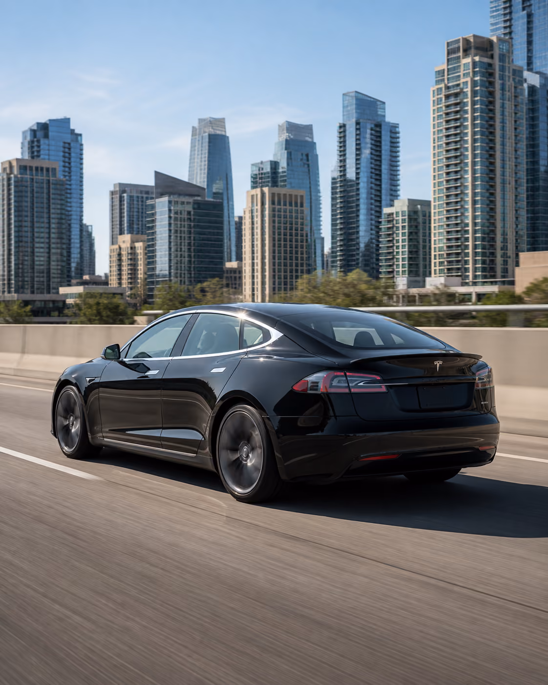 Tesla Model S driving toward the sunrise on a mountain road
