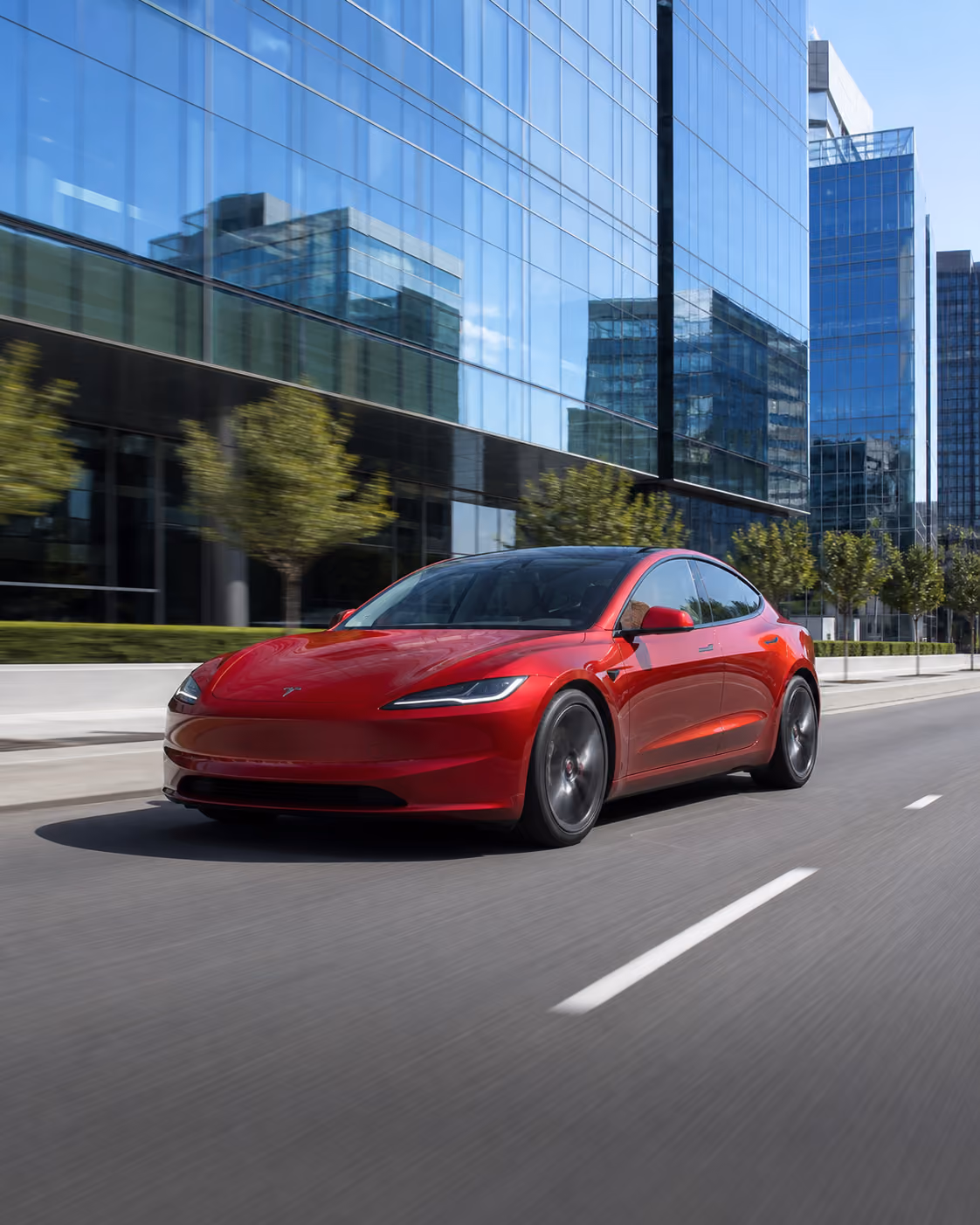 Red Tesla Model 3 showcased in a dark studio setting