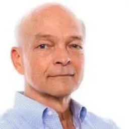 Portrait of Tom Lubinski wearing a light blue shirt and looking at the camera with a neutral expression. 